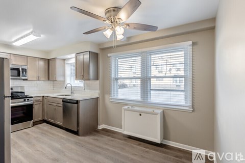 A kitchen with a fan and a window with blinds.