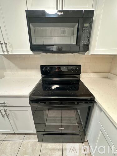 A black stove top oven with a microwave above it.
