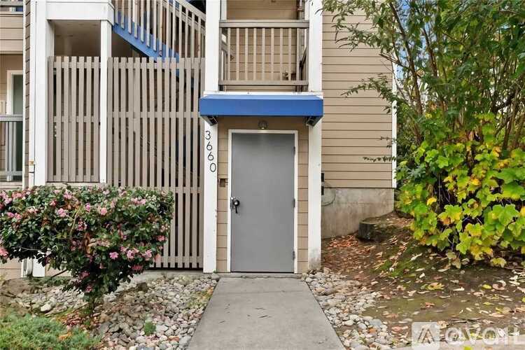 A building with a grey door and a blue awning.