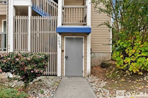 A building with a grey door and a blue awning.