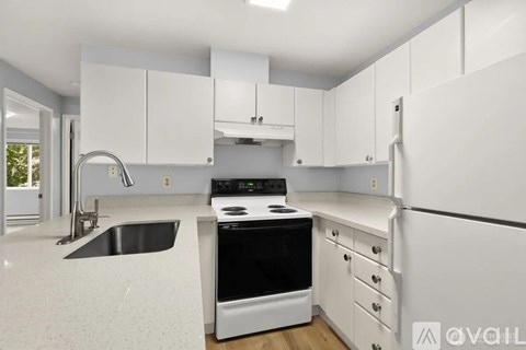 A modern kitchen with white cabinets and appliances.