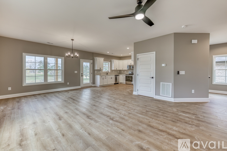 A spacious living room with a fan and hardwood flooring.