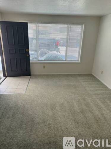 A room with a carpeted floor and a window showing a snowy scene outside.