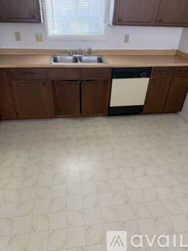 A kitchen with brown cabinets and a white dishwasher.