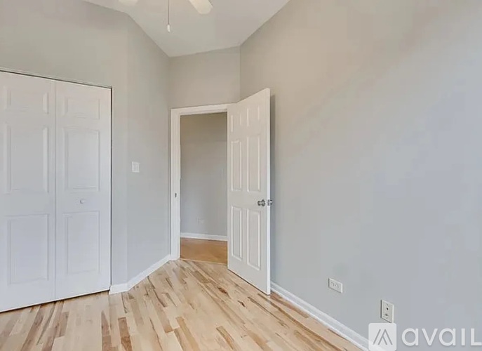 A room with a white door and a wooden floor.