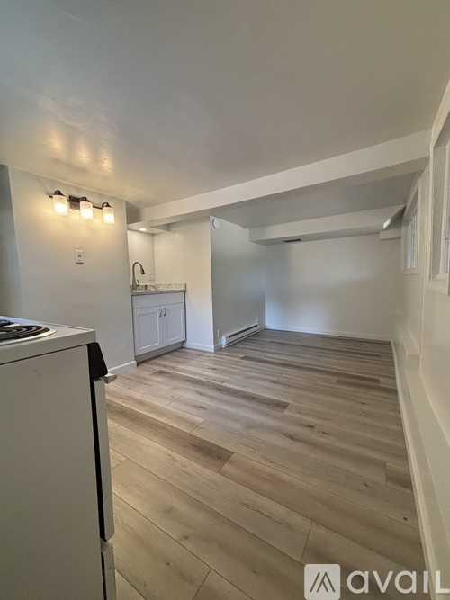 A kitchen with a white fridge and wooden floors.