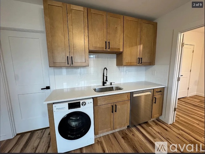 A kitchen with wooden cabinets and a white washing machine.