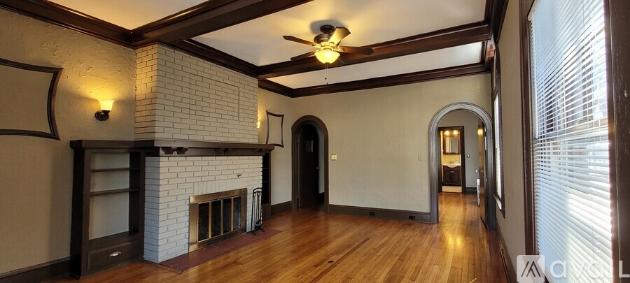 A room with a fireplace and a ceiling fan.