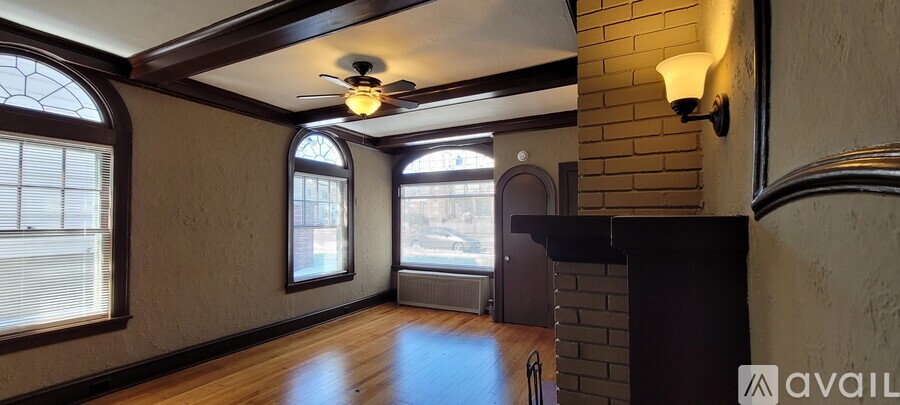 A room with a brick wall and a ceiling fan.