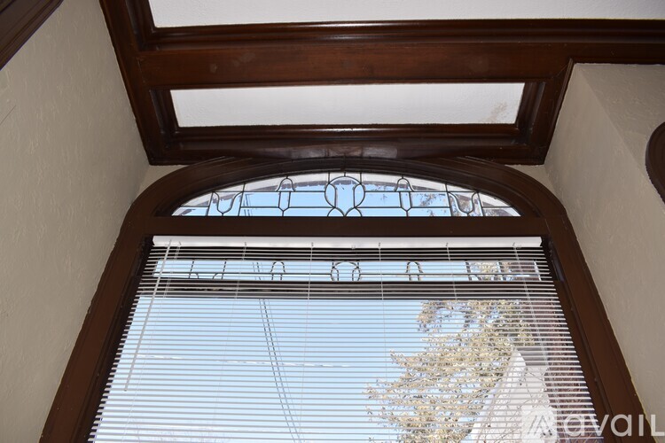 A window with blinds and a stained glass design.