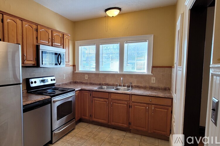 A kitchen with a stove, oven, microwave, and sink.