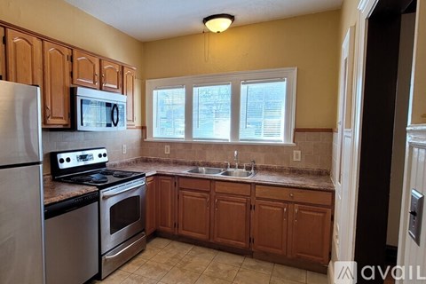 A kitchen with a stove, oven, microwave, and sink.