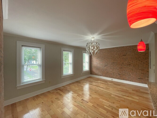A room with wooden flooring and a brick wall.