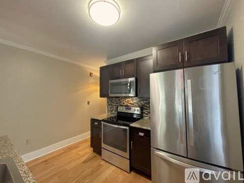 A kitchen with a stainless steel refrigerator and microwave.