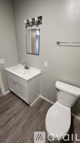 A white toilet sits next to a sink in a bathroom.