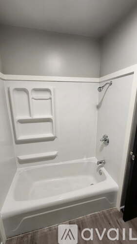 A white bathtub with a shower head attached to the side.