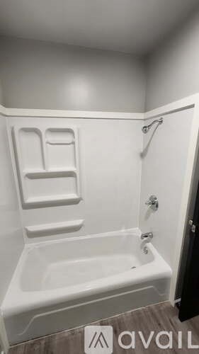 A white bathtub with a shower head attached to the side.