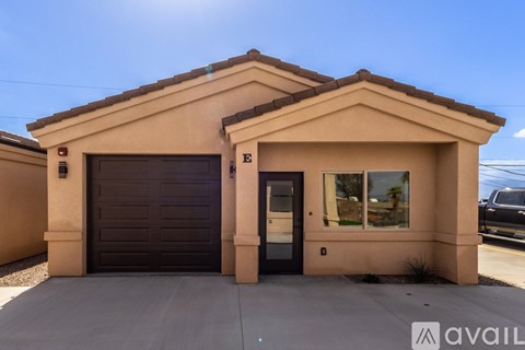 A house with a brown garage door and a black truck parked in the background.