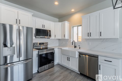 A kitchen with white cabinets and stainless steel appliances.