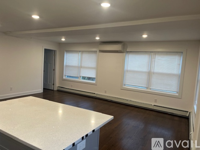 A spacious room with a large table and two windows.