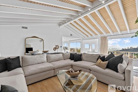 A living room with a large sectional sofa and a coffee table.