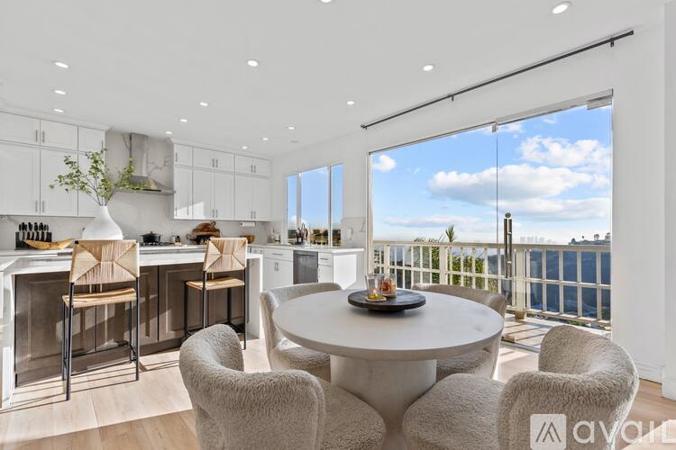 A modern kitchen with a dining table and chairs.