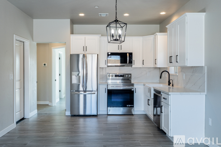 A modern kitchen with white cabinets and stainless steel appliances.