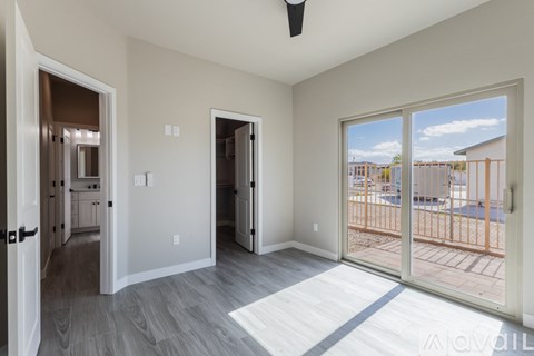 A spacious living room with a sliding glass door leading to a balcony.