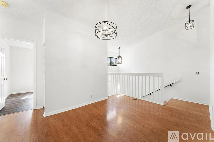 A living room with a white wall and a wooden floor.