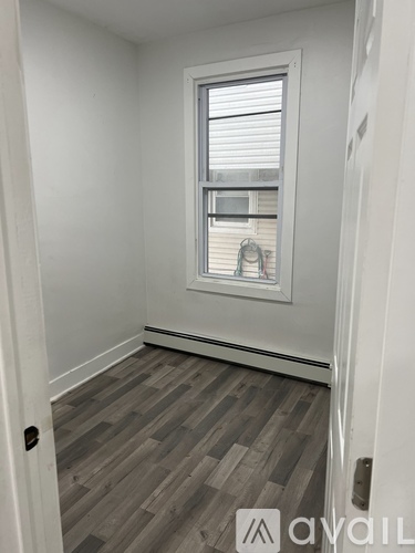 A room with a window and wooden flooring.