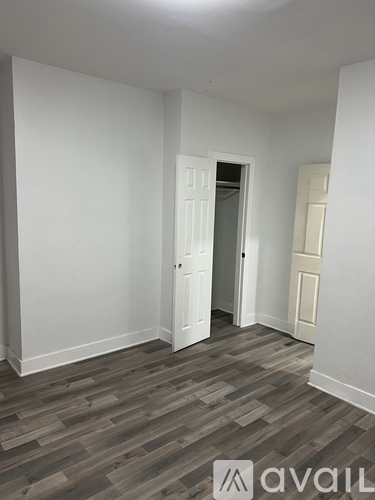 A room with a wooden floor and white walls.