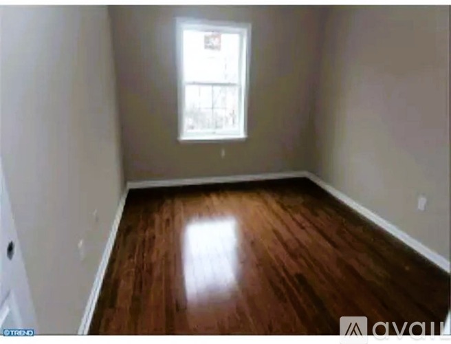 A room with wooden flooring and a window.