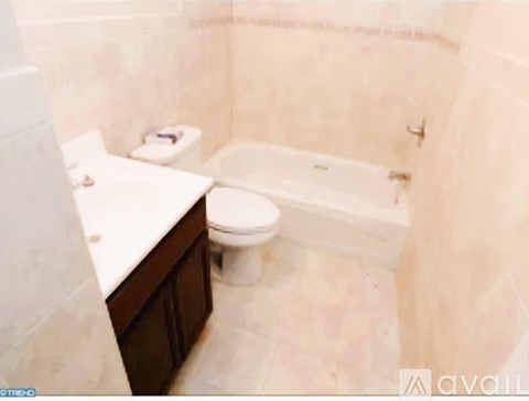 A bathroom with a toilet, sink, and bathtub.