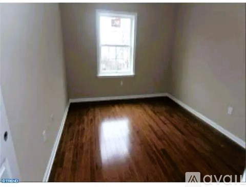 A room with wooden flooring and a window.