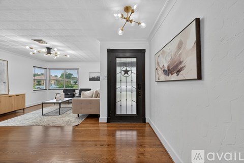 A modern living room with a wooden floor and a large painting on the wall.