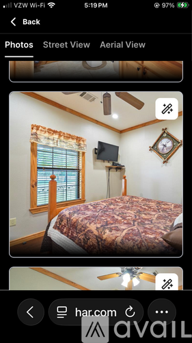 A bedroom with a bed, a window with blinds, and a clock on the wall.
