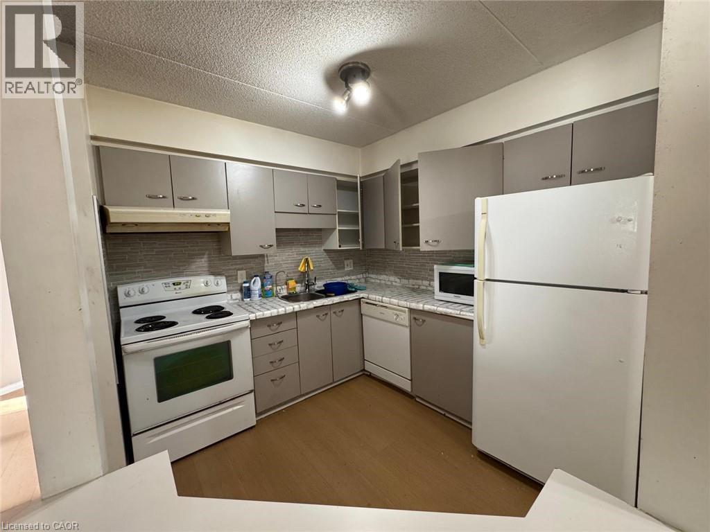 A white refrigerator is in a kitchen with white cabinets.