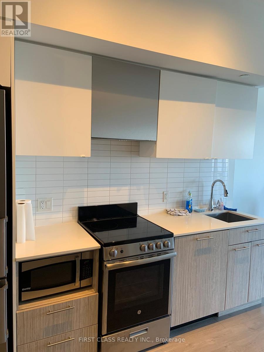A kitchen with a black stove top oven and white cabinets.