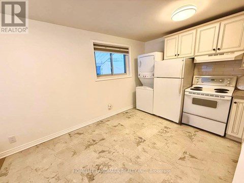 A kitchen with a window, a fridge, a stove and an oven.