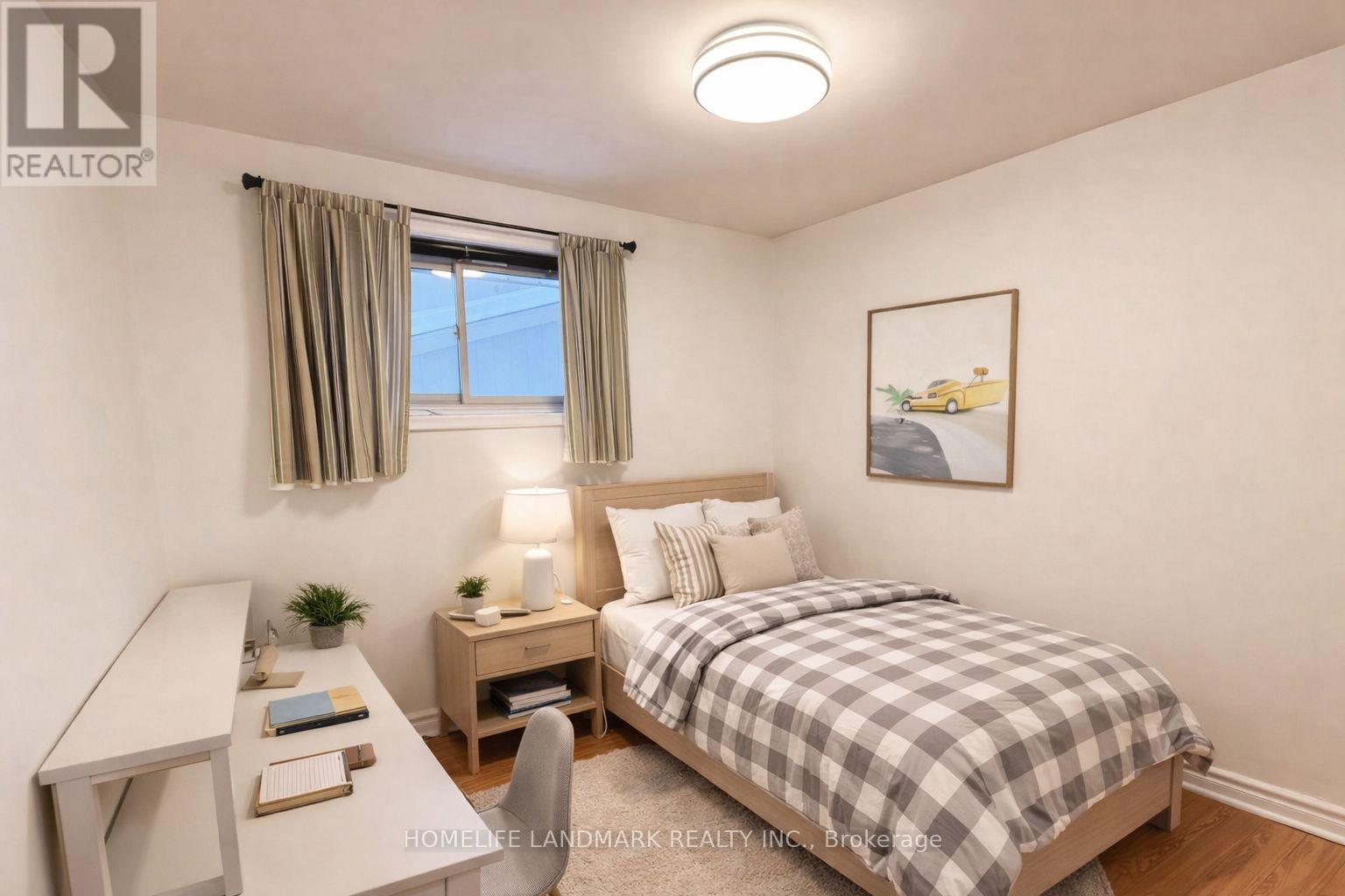 A bedroom with a bed, desk, and window.