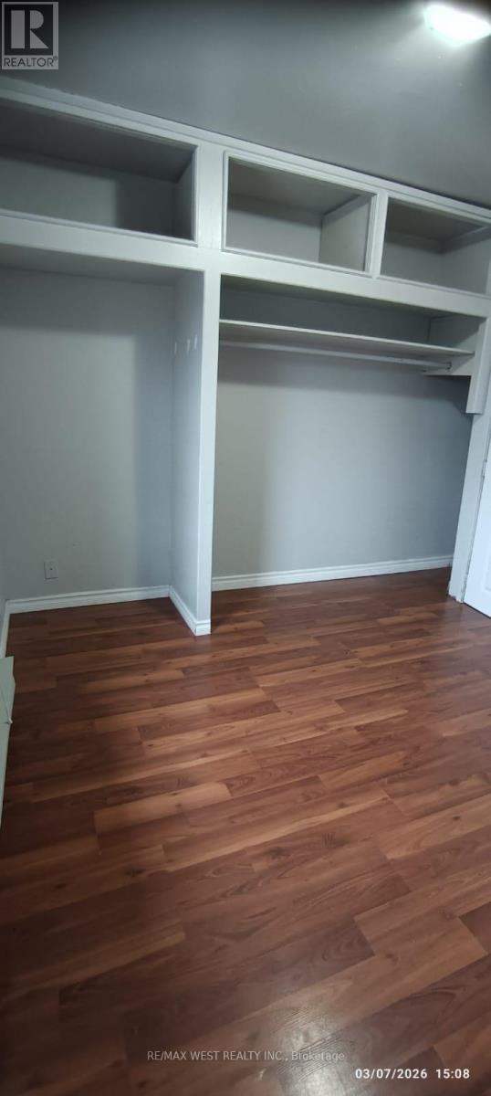 A room with wooden flooring and white walls.
