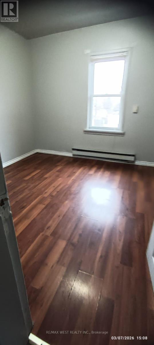 A room with wooden flooring and a window.
