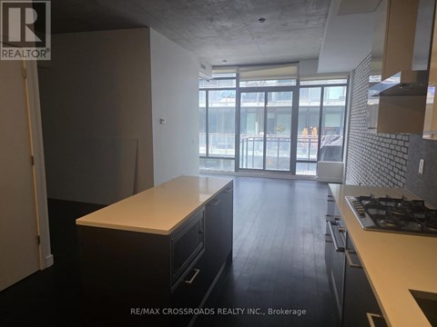 A kitchen with a white counter top and black cabinets.