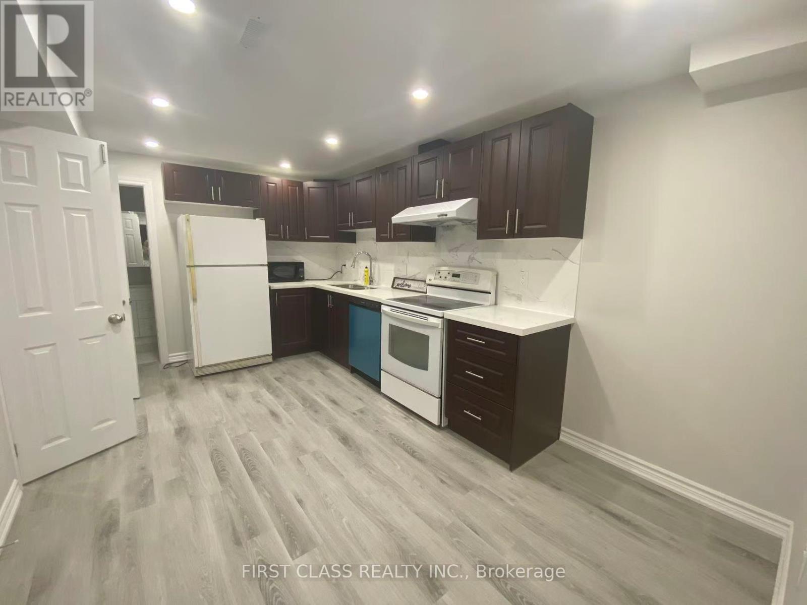 A kitchen with a white refrigerator, white stove, and white oven.