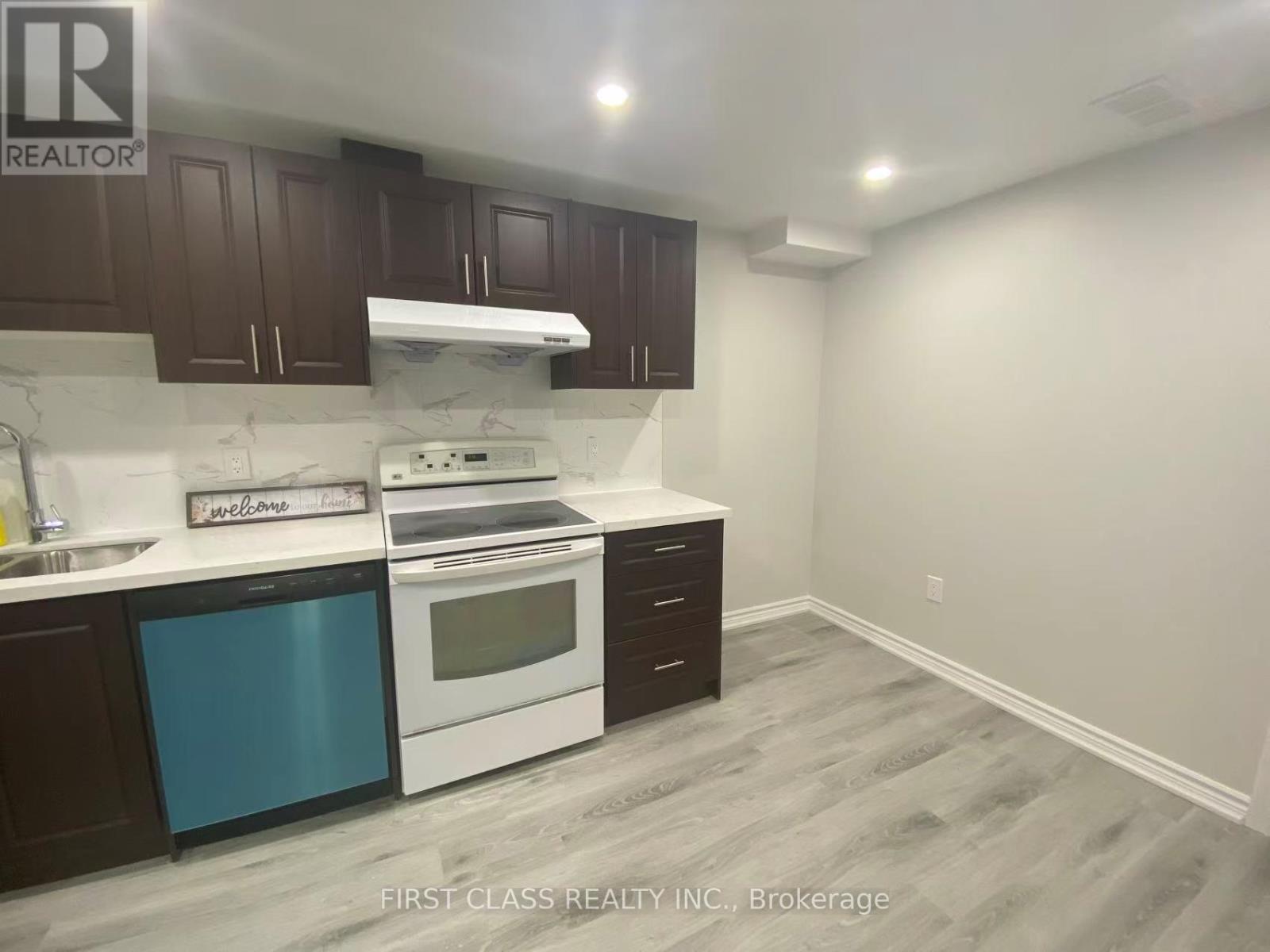 A kitchen with a white stove top oven and a white range hood.