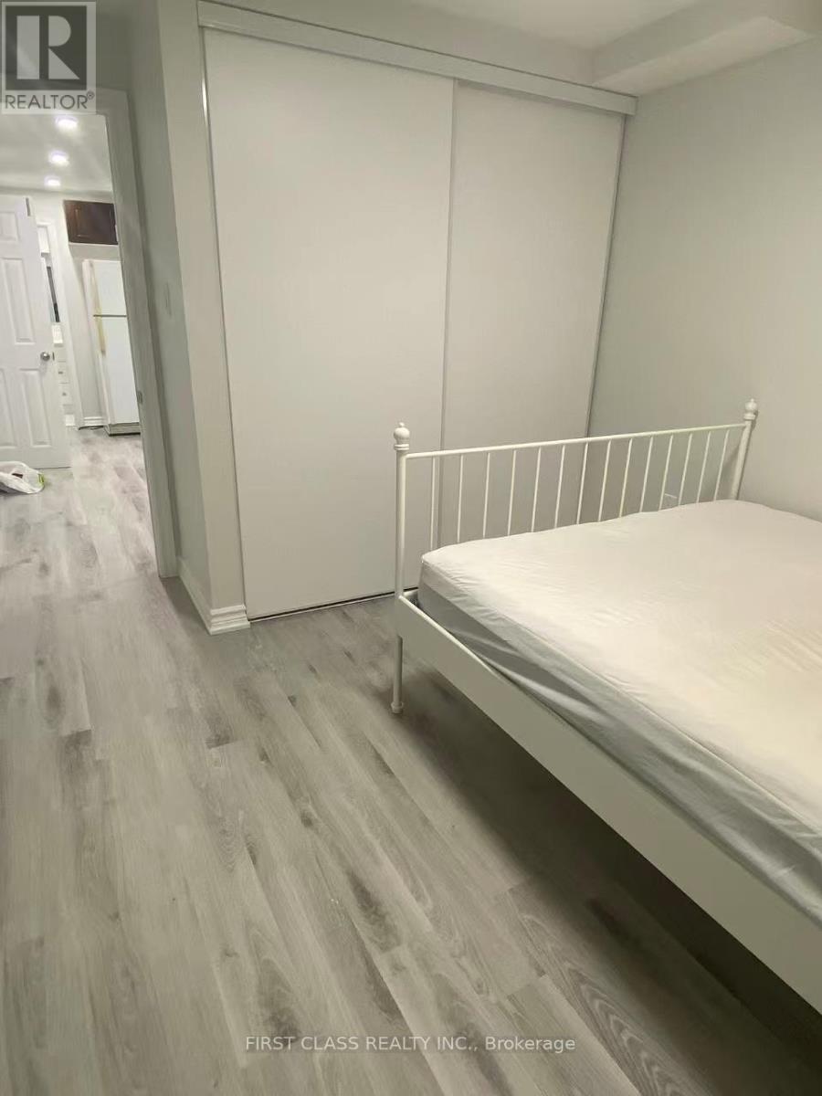A bedroom with a bed, wardrobe and a wooden floor.