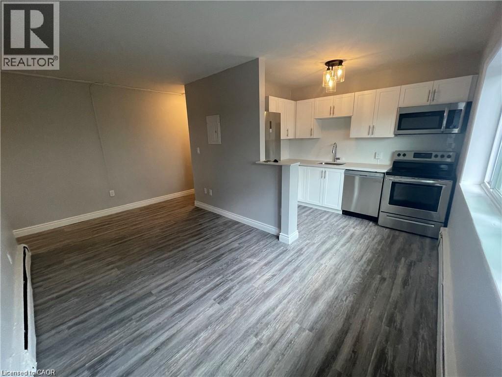 A kitchen with a grey floor and white cabinets.