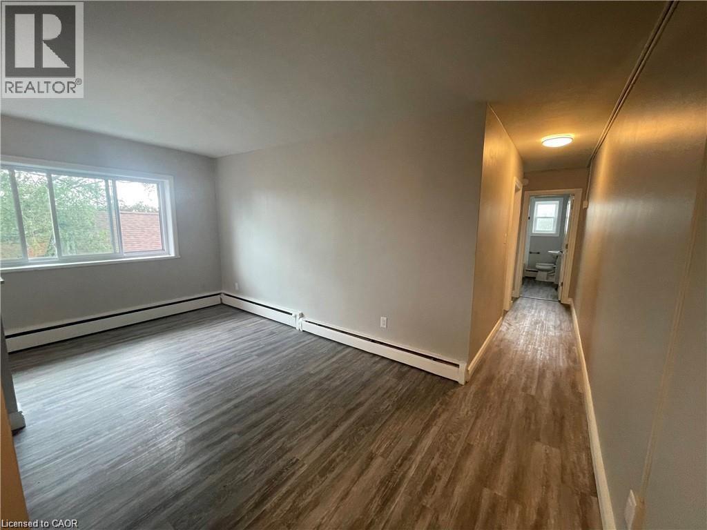 A long hallway with wood flooring and white walls.