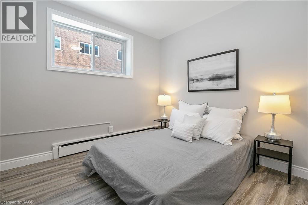 A bedroom with a bed, two lamps, and a framed picture on the wall.