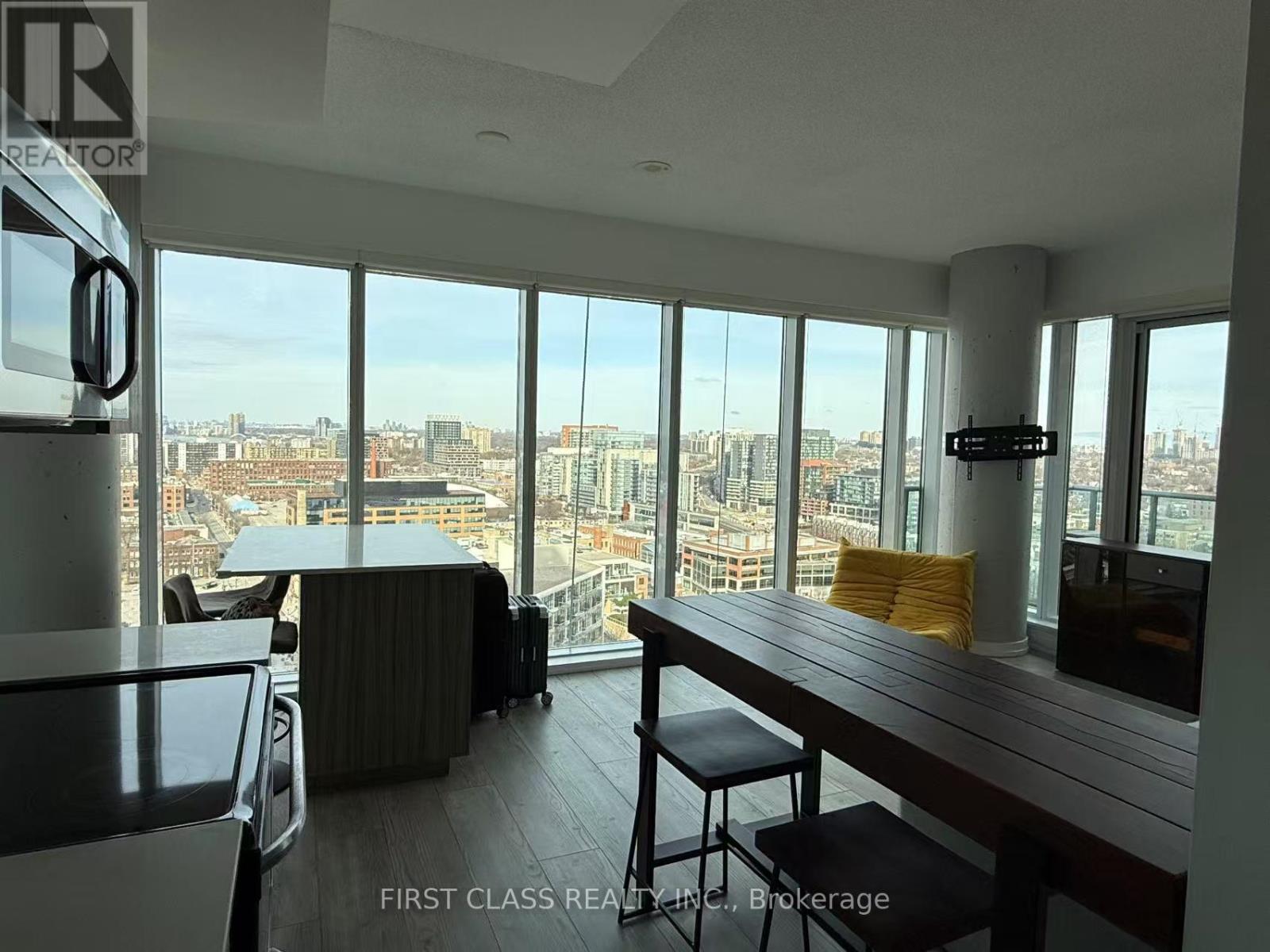 A room with a long table and chairs with a view of the city.